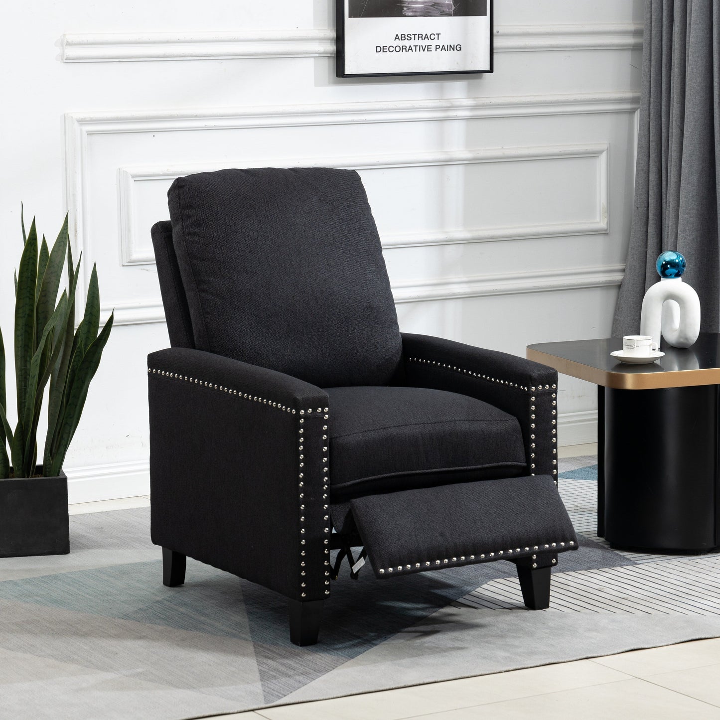 Poltrona reclinabile manuale moderna rivestita in velluto nero con morbidi cuscini e poggiapiedi, decorazione con borchie