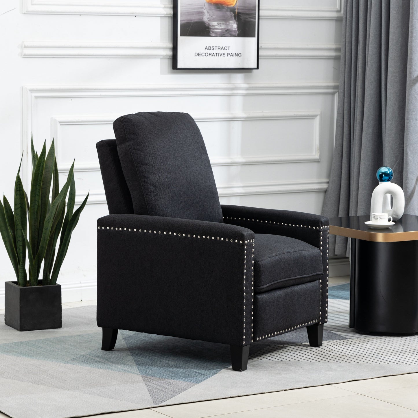 Poltrona reclinabile manuale moderna rivestita in velluto nero con morbidi cuscini e poggiapiedi, decorazione con borchie