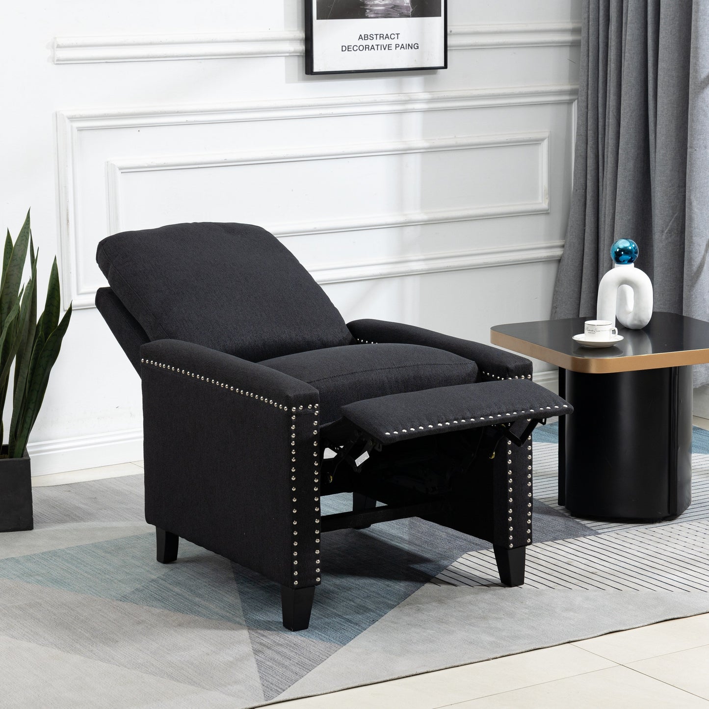 Poltrona reclinabile manuale moderna rivestita in velluto nero con morbidi cuscini e poggiapiedi, decorazione con borchie