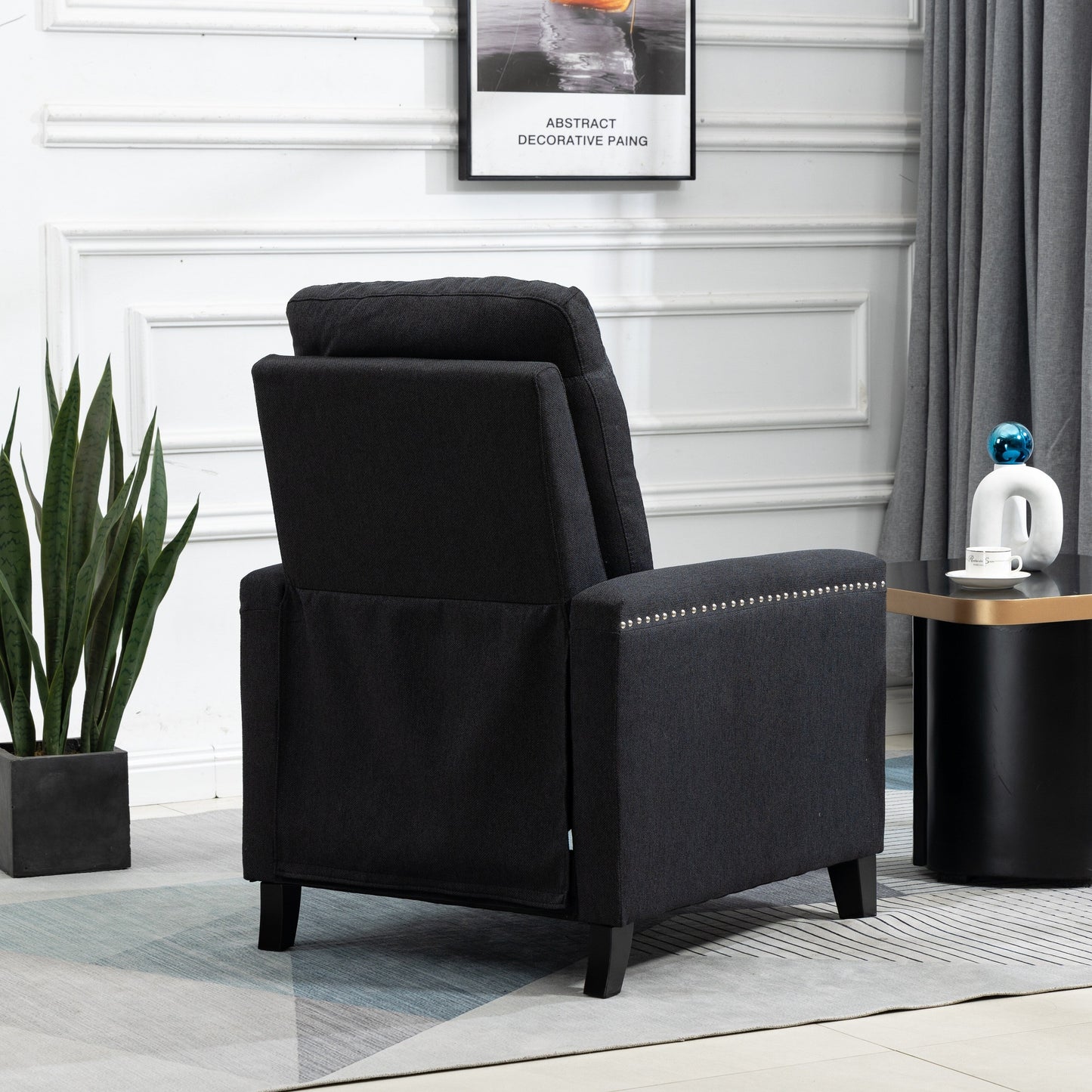 Poltrona reclinabile manuale moderna rivestita in velluto nero con morbidi cuscini e poggiapiedi, decorazione con borchie