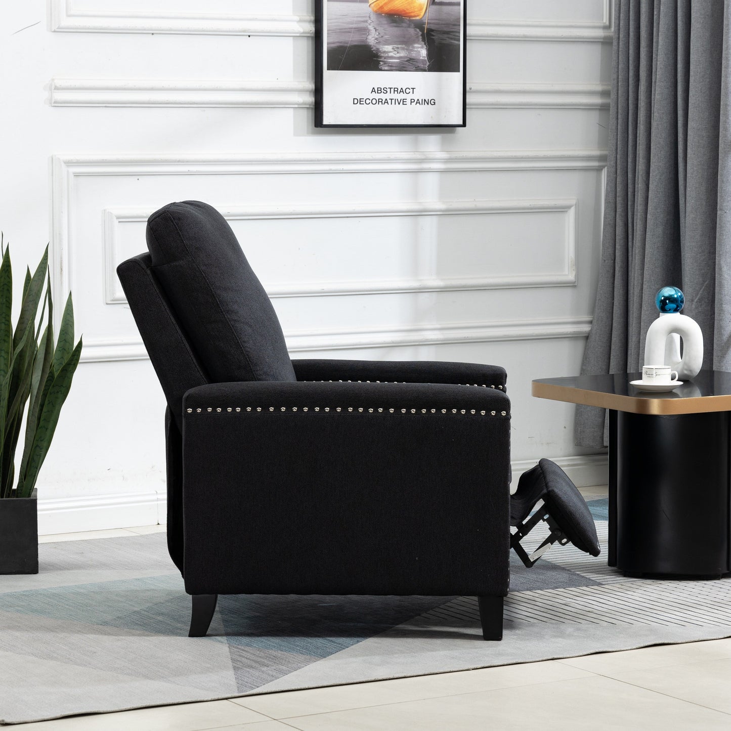 Poltrona reclinabile manuale moderna rivestita in velluto nero con morbidi cuscini e poggiapiedi, decorazione con borchie