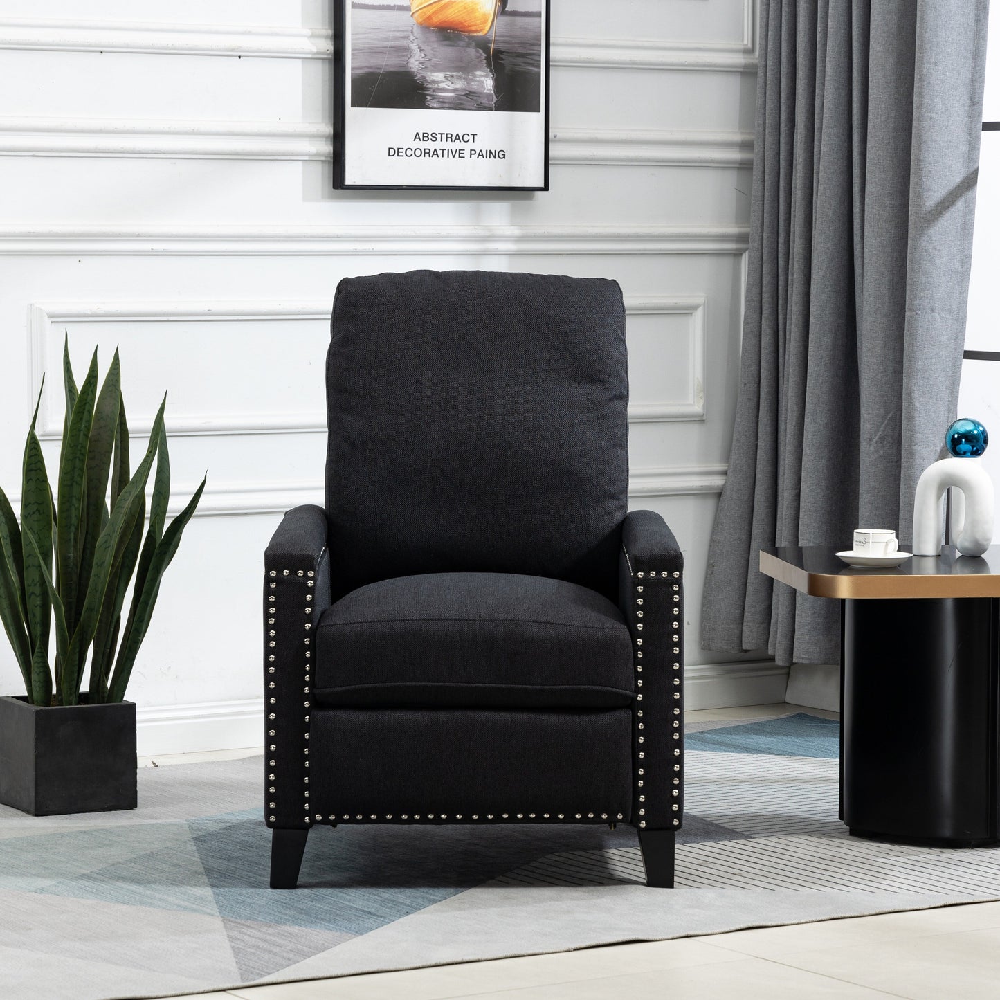 Poltrona reclinabile manuale moderna rivestita in velluto nero con morbidi cuscini e poggiapiedi, decorazione con borchie