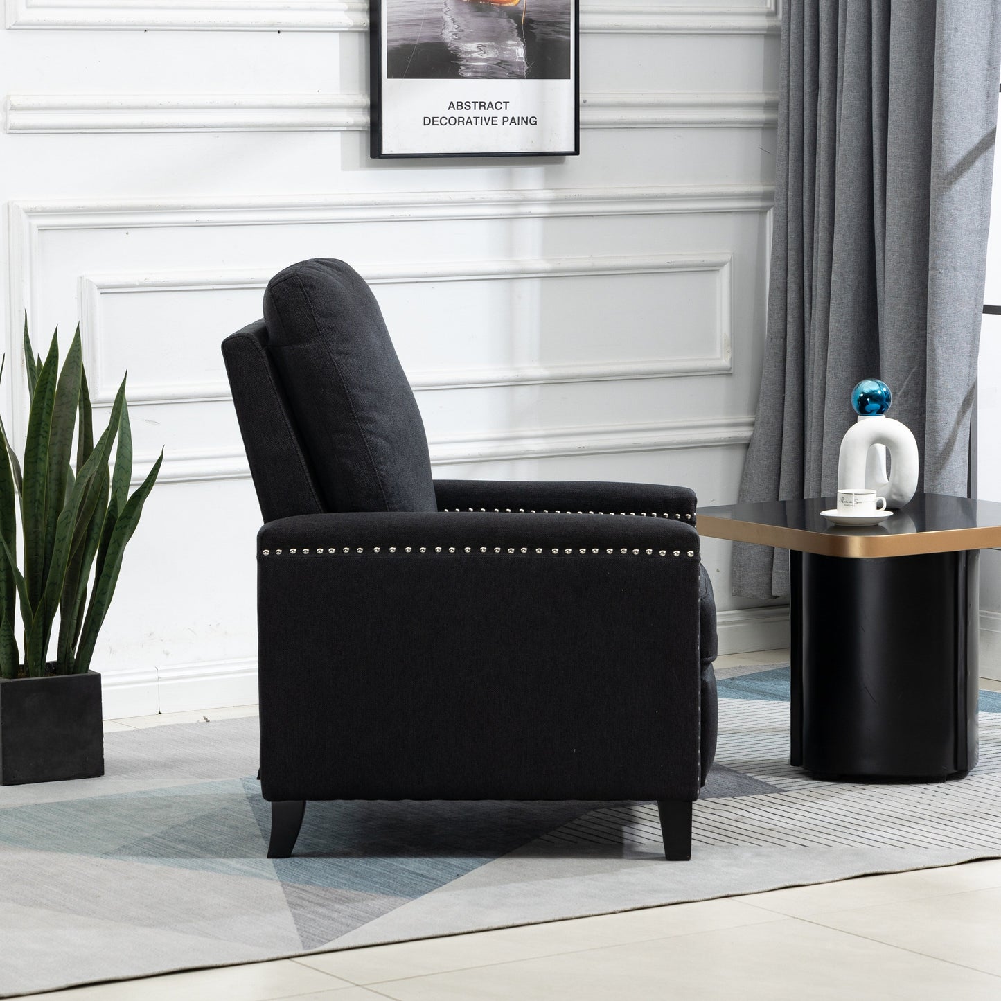 Poltrona reclinabile manuale moderna rivestita in velluto nero con morbidi cuscini e poggiapiedi, decorazione con borchie