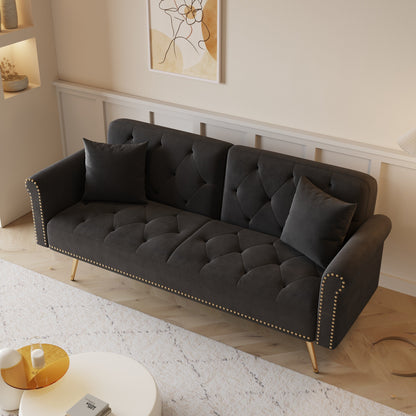 Un divano letto lungo 69,7 pollici rivestito in tessuto di velluto, con finiture a borchie e accompagnato da un cuscino coordinato.
