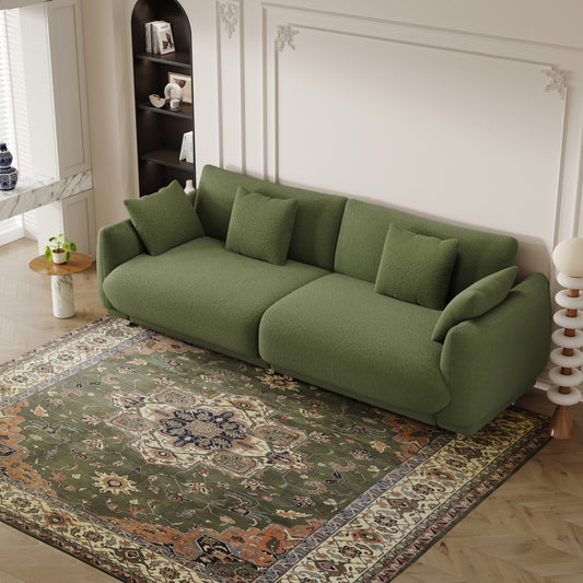 Un divano verde in lana teddy da 86,6 pollici con quattro cuscini e piedini in metallo che può stare comodamente in una camera da letto di un appartamento con